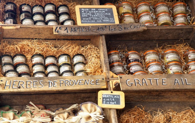 Imagem dos produtos artesanais na Rue du Vieux Sextier com uma banca com potes a frente. Representa o que fazer em Avignon.