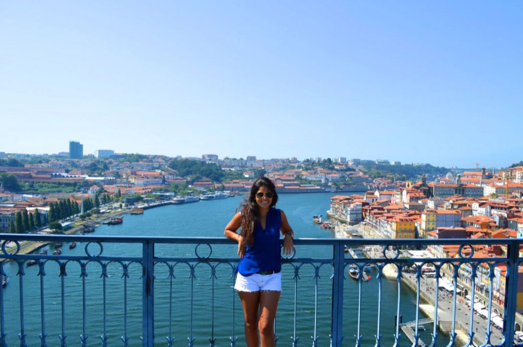 Foto com Virgínia Falanghe (colunista) na Ponte Luís VI, que liga as cidades de Porto e Vila Nova Gaia sobre o rio Douro, sugestão para conhecer no roteiro Portugal.