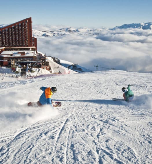Valle Nevado Ski Resort com hotéis ao fundo e pessoas esquiando. Foto do site oficial Valle Nevado. Representa onde ficar no Valle Nevado.
