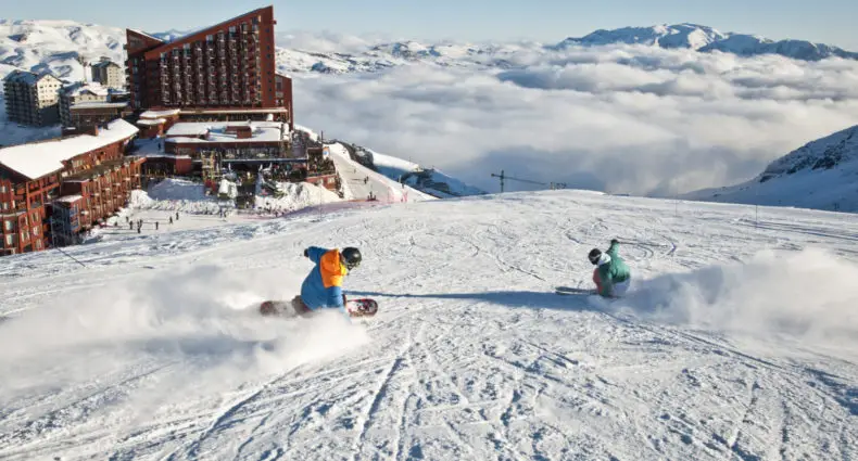 Valle Nevado Ski Resort com hotéis ao fundo e pessoas esquiando. Foto do site oficial Valle Nevado. Representa onde ficar no Valle Nevado.