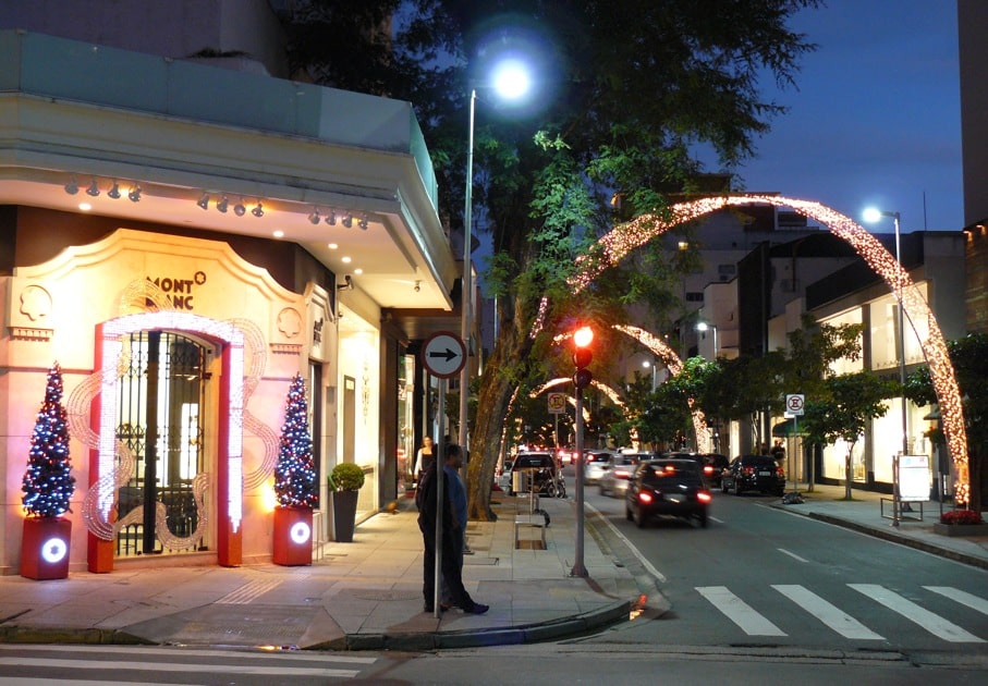 Na imagem vemos uma esquina da Rua Oscar Freire em SP, com decoração natalina de luzes e árvores com ornamentos. Foto de Peteris via Flickr.