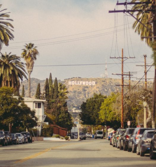 Foto de rua em Los Angeles com placa de Hollywood ao fundo