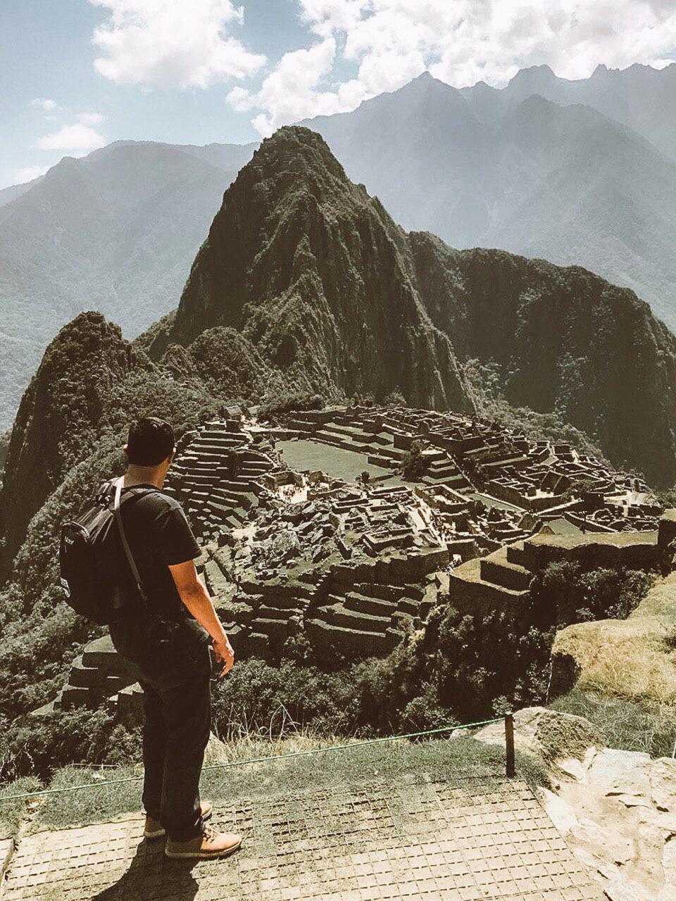 homem de costas, em pé, em frente a cidade perdida dos incas: Machu picchu, vista de cima.