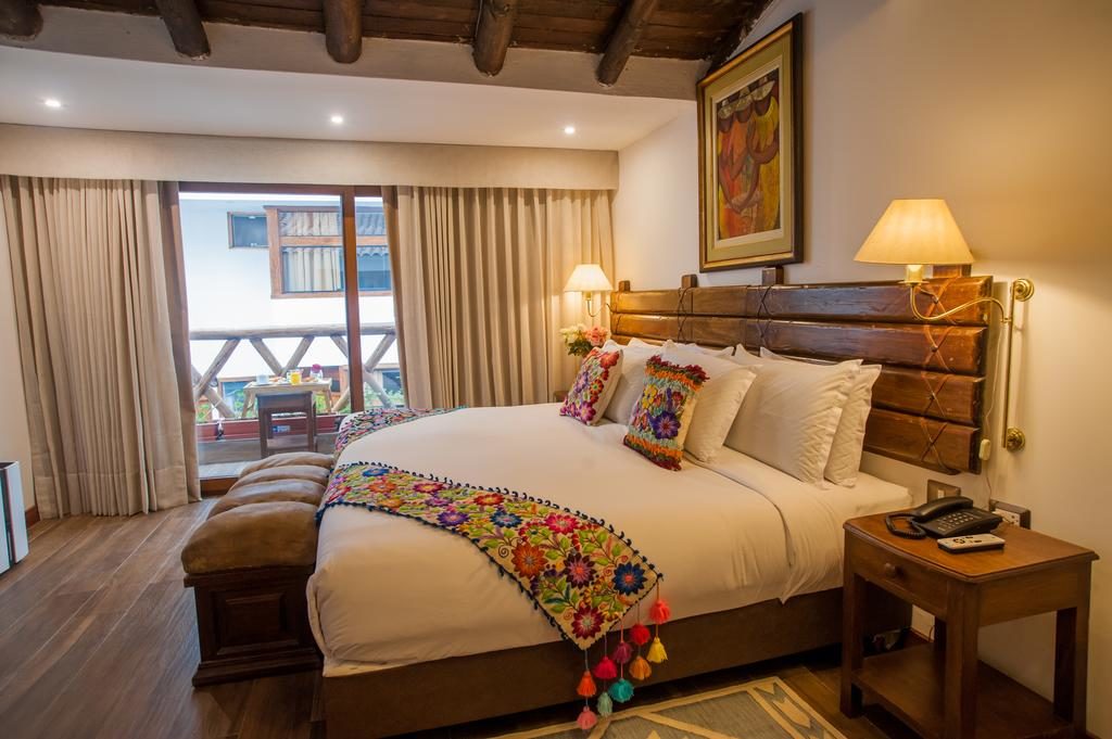 Foto de quarto com cama espaçosa, confortável e decoração andina no La Cabaña Hotel.