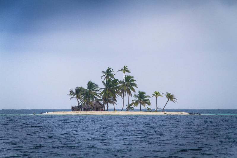 Foto de ilha pequena do arquipélago de San Blas, com poucas palmeiras e uma cabana ao centro