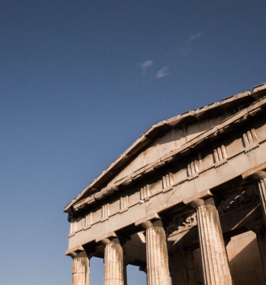 Atenas, na Grécia, com céu limpo e monumento antigo em primeiro plano