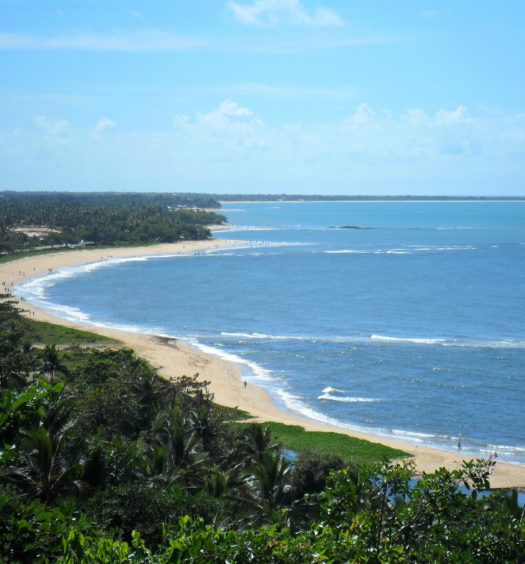 Praia com extensa faixa de areia e mata na Bahia