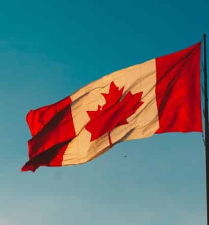 Bandeira do Canadá hasteada com céu azul ao fundo