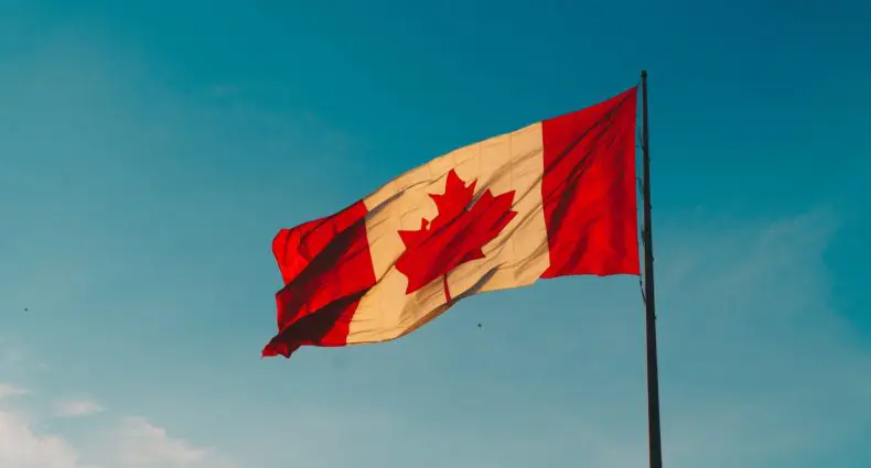 Bandeira do Canadá hasteada com céu azul ao fundo