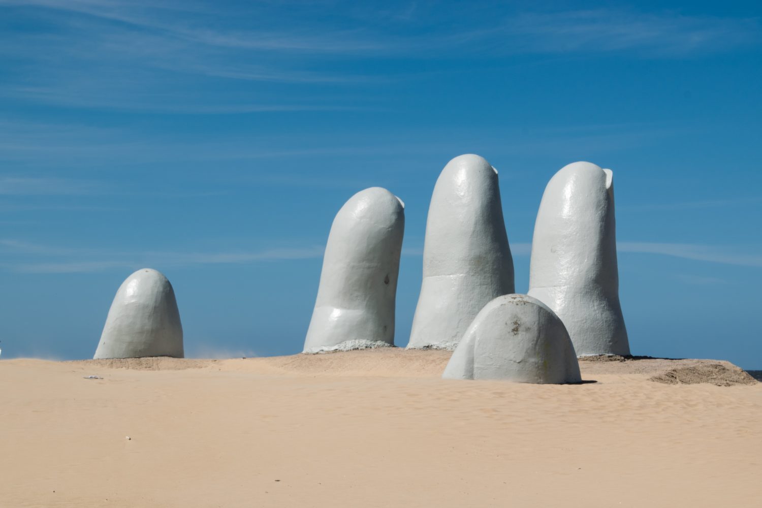 estátua cinza de dedos saindo da areia em punta del este no uruguai