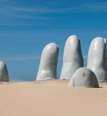 estátua cinza de dedos saindo da areia em punta del este no uruguai