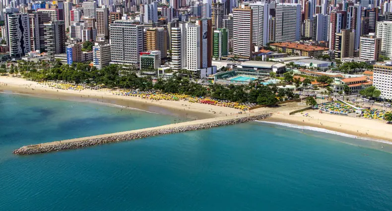 Orla do mar em Fortaleza, com diversos prédios e longa ponte