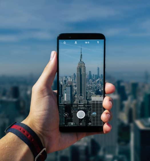 pessoa fotografando com o celular o empire state building em nova york nos estados unidos