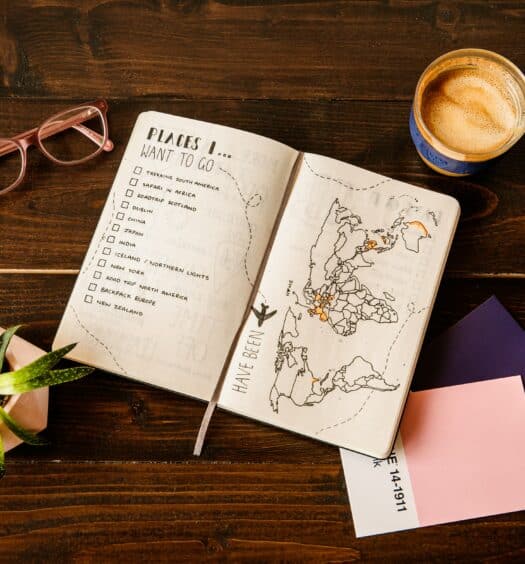 caderno aberto com planos sobre os países que deseja visitar com um seguro viagem internacional