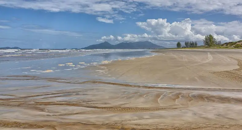 Vista de praia em Ilha Comprida, com vales do continente ao fundo