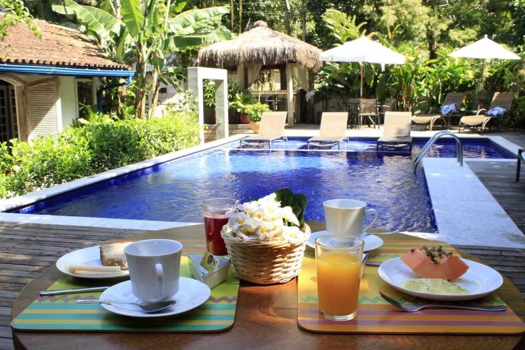 Café da manhã ao lado da piscina da Pousada Canto do Camburi