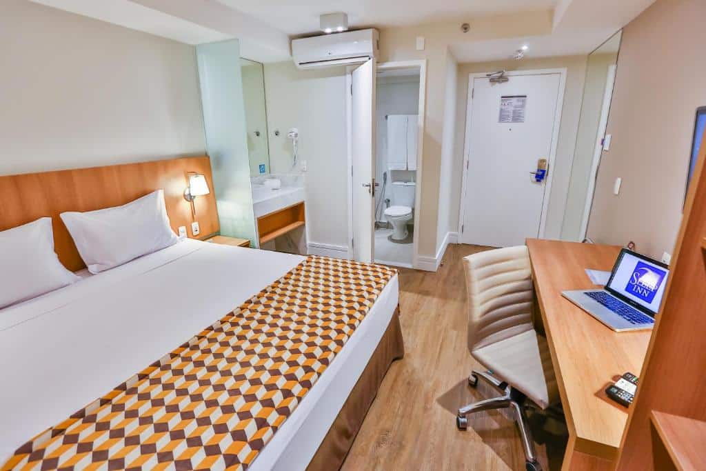 Quarto em um dos hotéis perto do Aeroporto de Guarulhos, o Sleep Inn, com cama de casal ampla, ar-condicionado e banheiro