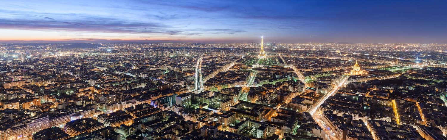 O horizonte de Paris ao anoitecer, com a Torre Eiffel iluminada, na capa do post sobre hotéis perto da Torre Eiffel