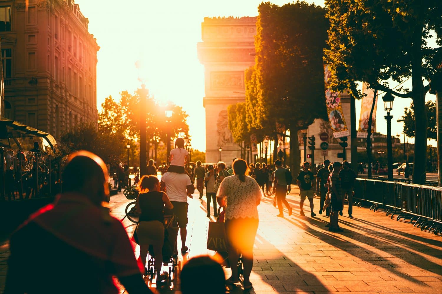 Arco do Triunfo com pessoas próximas, ilustrando post de hotéis para famílias em Paris
