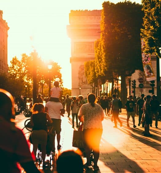 Arco do Triunfo com pessoas próximas, ilustrando post de hotéis para famílias em Paris