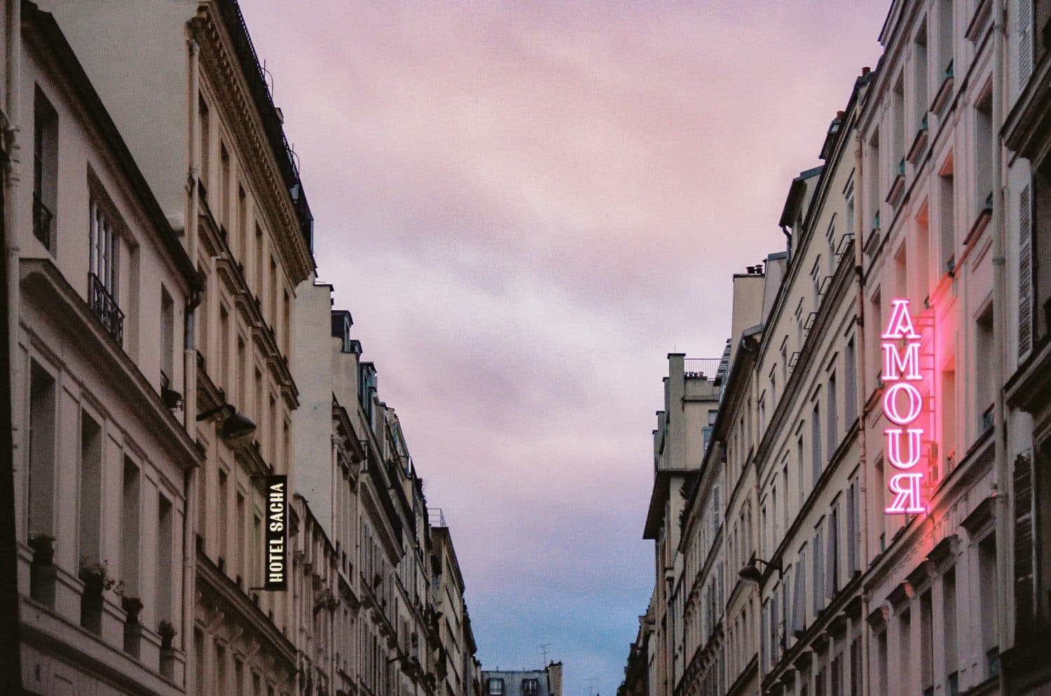 Edifício com placa "Amour" ilustrando post de hotéis românticos em Paris