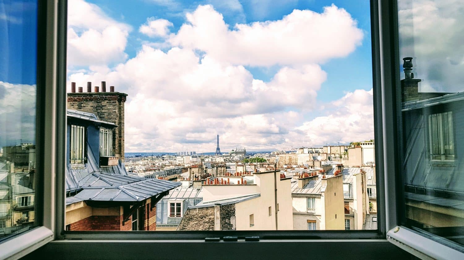Janela no centro de Paris com vista para a Torre Eiffel, ilustrando post de Airbnb em Paris