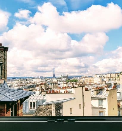 Janela no centro de Paris com vista para a Torre Eiffel, ilustrando post de Airbnb em Paris
