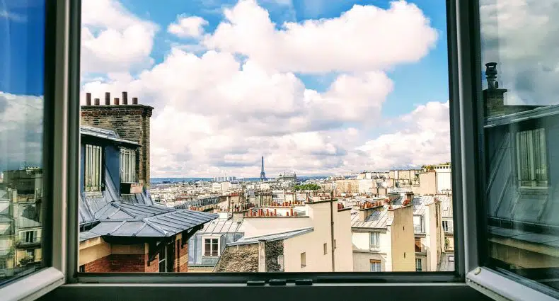 Janela no centro de Paris com vista para a Torre Eiffel, ilustrando post de Airbnb em Paris