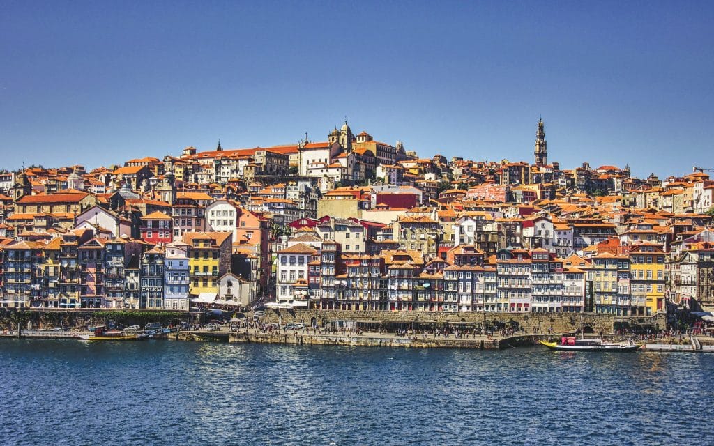 Vista das casinhas coloridas na Ribeira, às margens do Douro durante o dia.