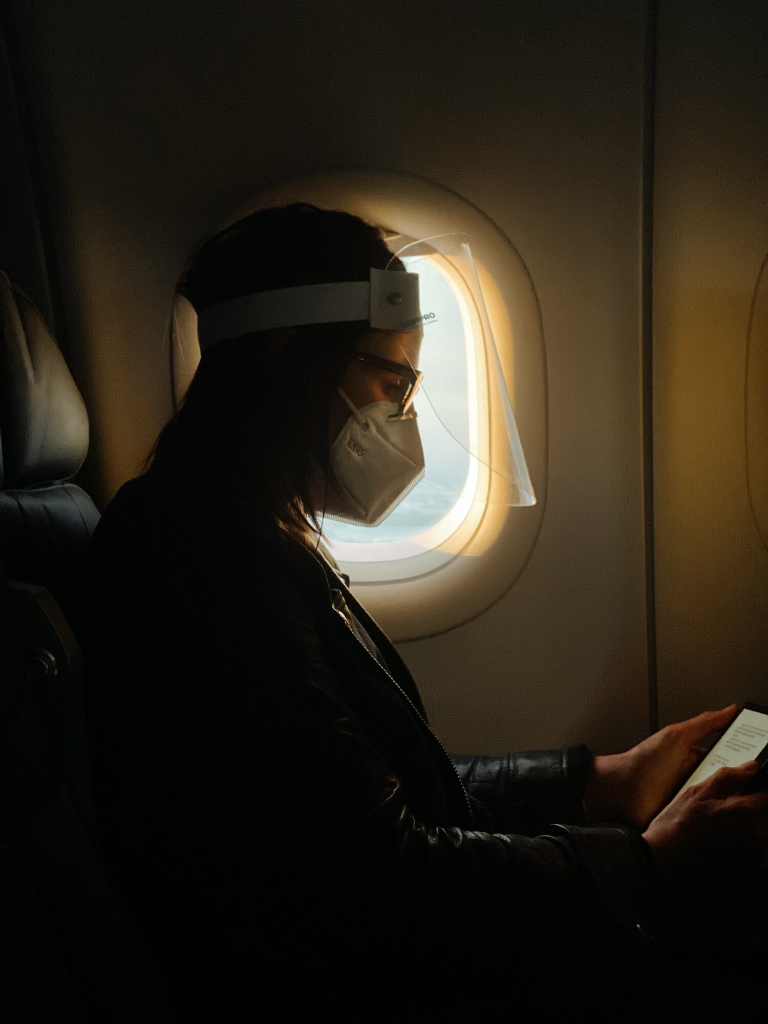 mulher usando máscara em sua viagem de avião