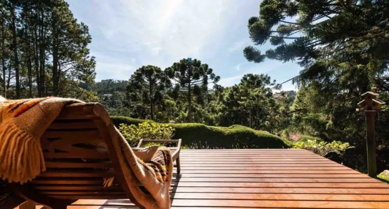 Vista do deck da Casa Xamego Alto Padrão em Campos do Jordão, direcionando para a floresta e as montanhas