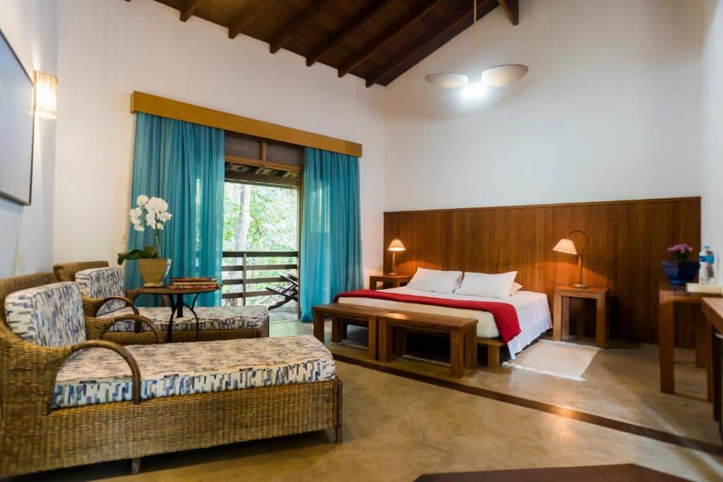 Quarto super espaçoso, com cama king size, varanda e divãs, na Guest House Ilha Splendor, uma das alternativas às pousadas em Ilhabela