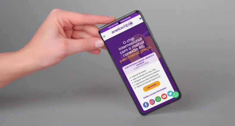 mão branca segurando pelo canto direito superior um celular android com a tela mostrando a página inicial da america chip