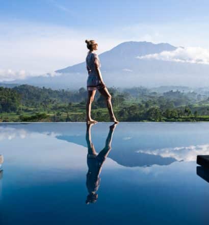 Pessoa em piscina de borda infinita em Bali, ilustrando post sobre Universal Assistance
