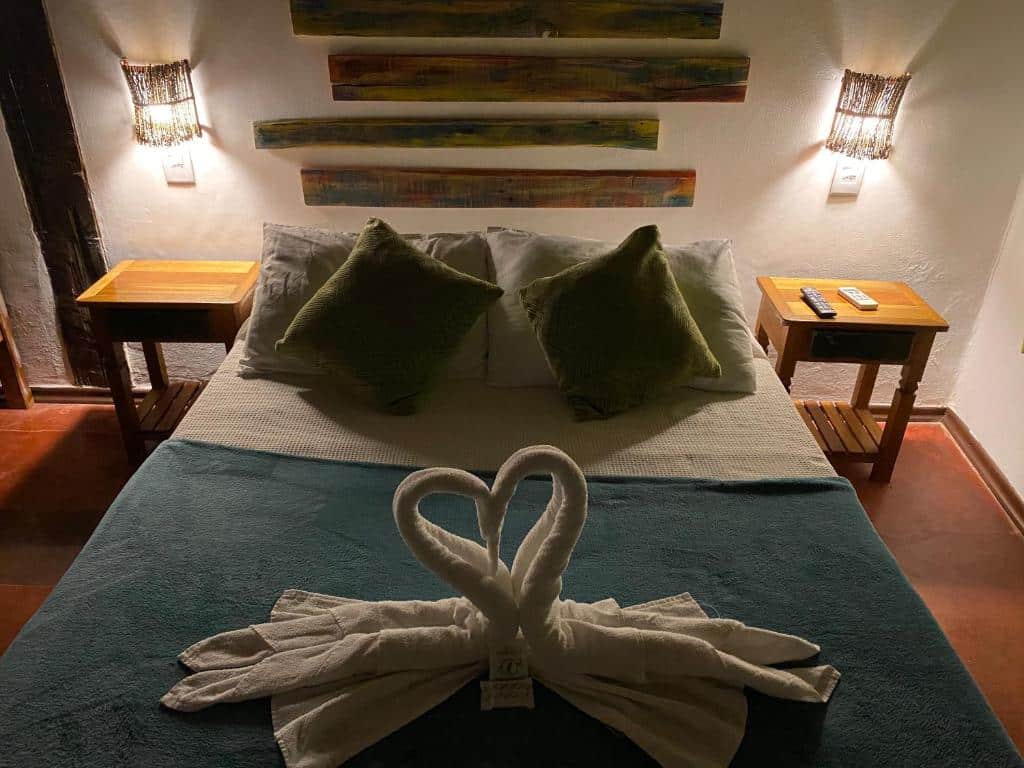 Quarto da Vila Pequeá Ilhabela, com cama de casal e toalhas dobradas como se fossem gansos