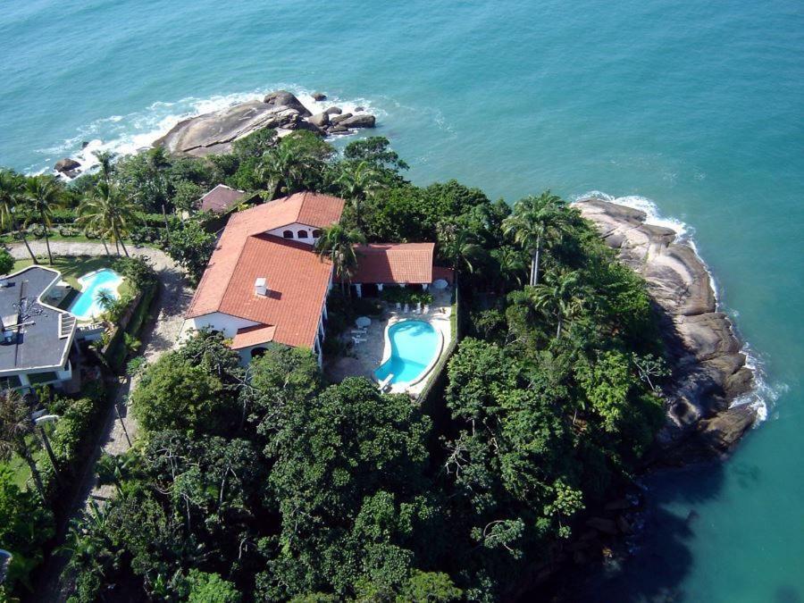Vista aérea da Casa Genoveva na Praia do Tenório, cercado pelo mar, rochas e vegetação