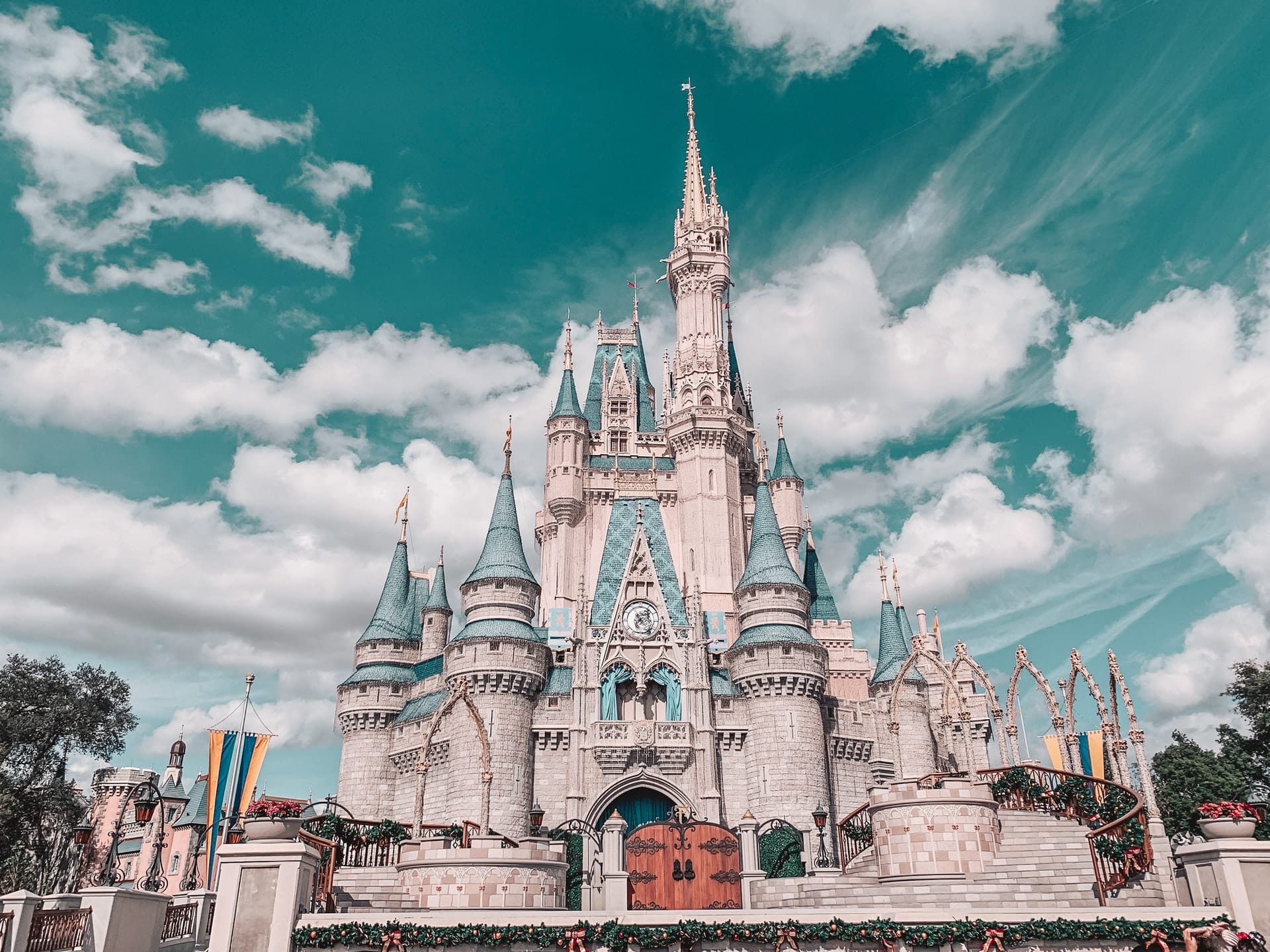 vista do Castelo da Cinderela na Disney em Orlando com grandes torres pontudas e um céu azulado com nuvens brancas