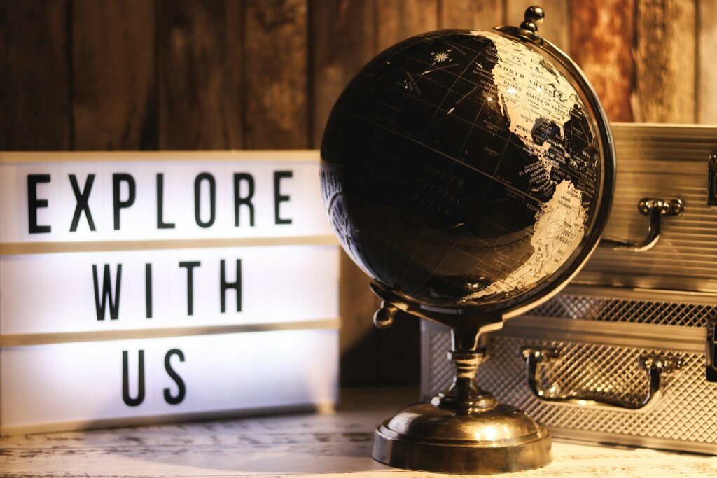placa de luz escrito "explore with us" com um globo do mapa mundi representando a importância de um seguro viagem