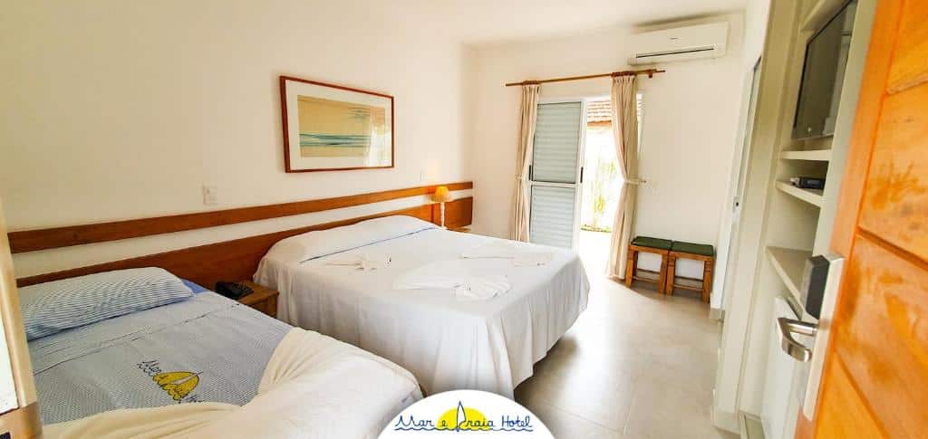 Quarto do Mar e Praia Hotel, na Praia da Enseada, em Ubatuba, com uma cama de casal e uma cama de solteiro, frigobar, ar-condicionado e armário
