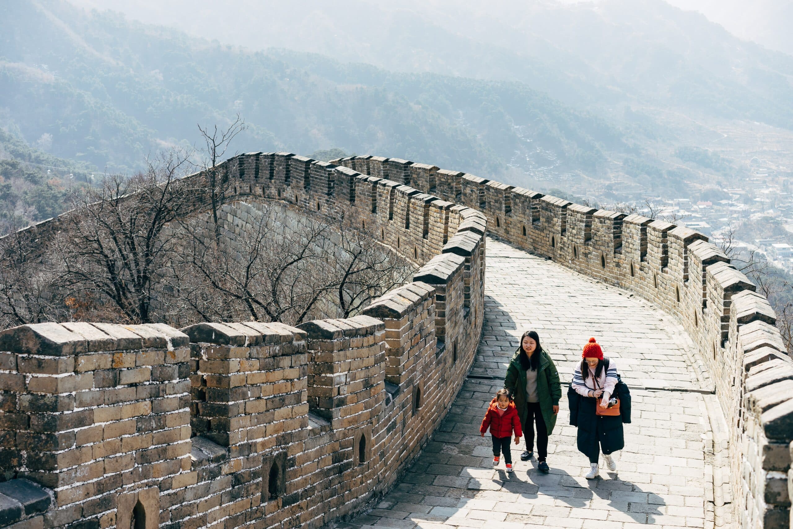 família caminhando sobre a grande muralha da china