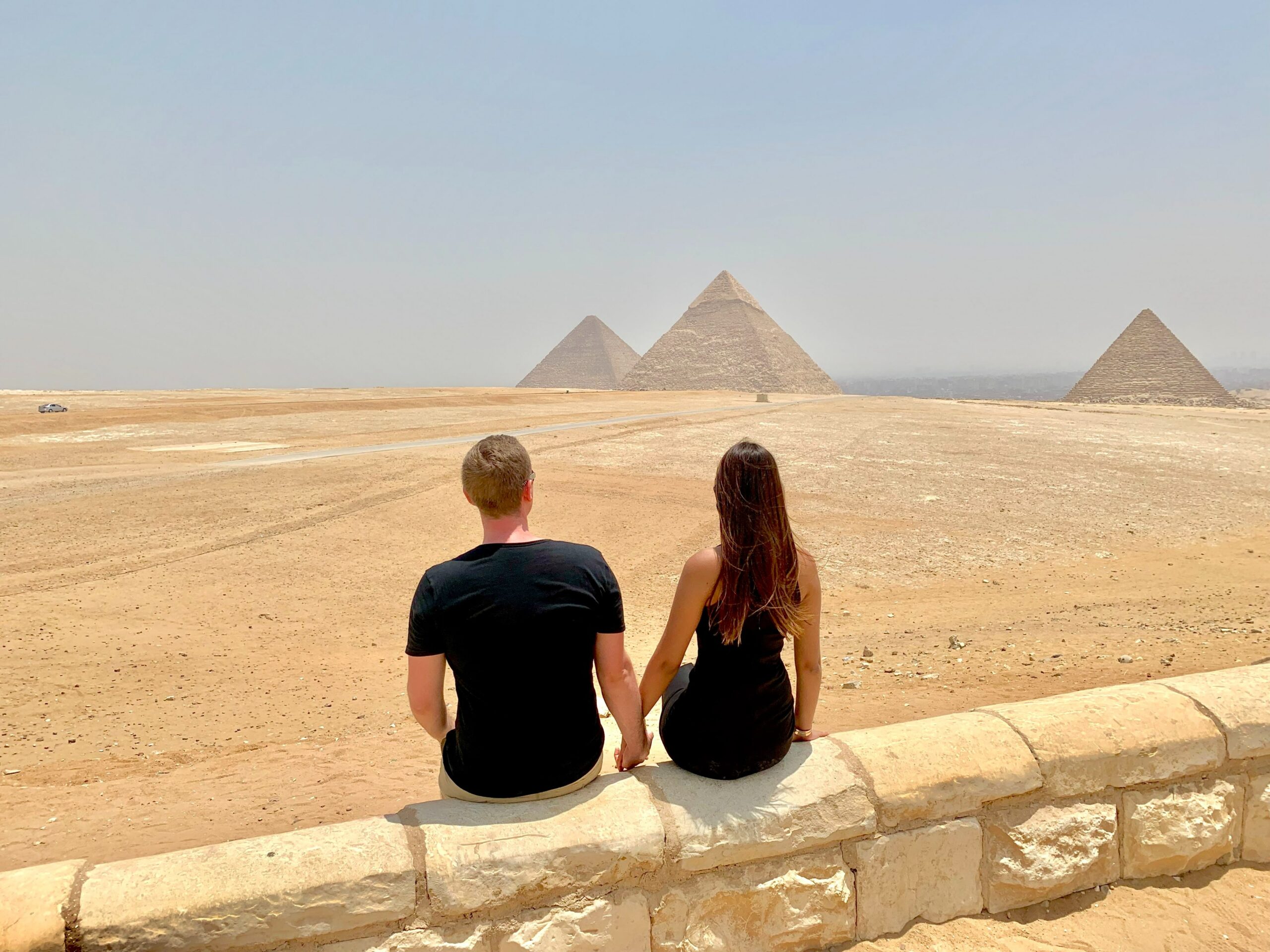 casal no cairo, egito olhando para as piramides