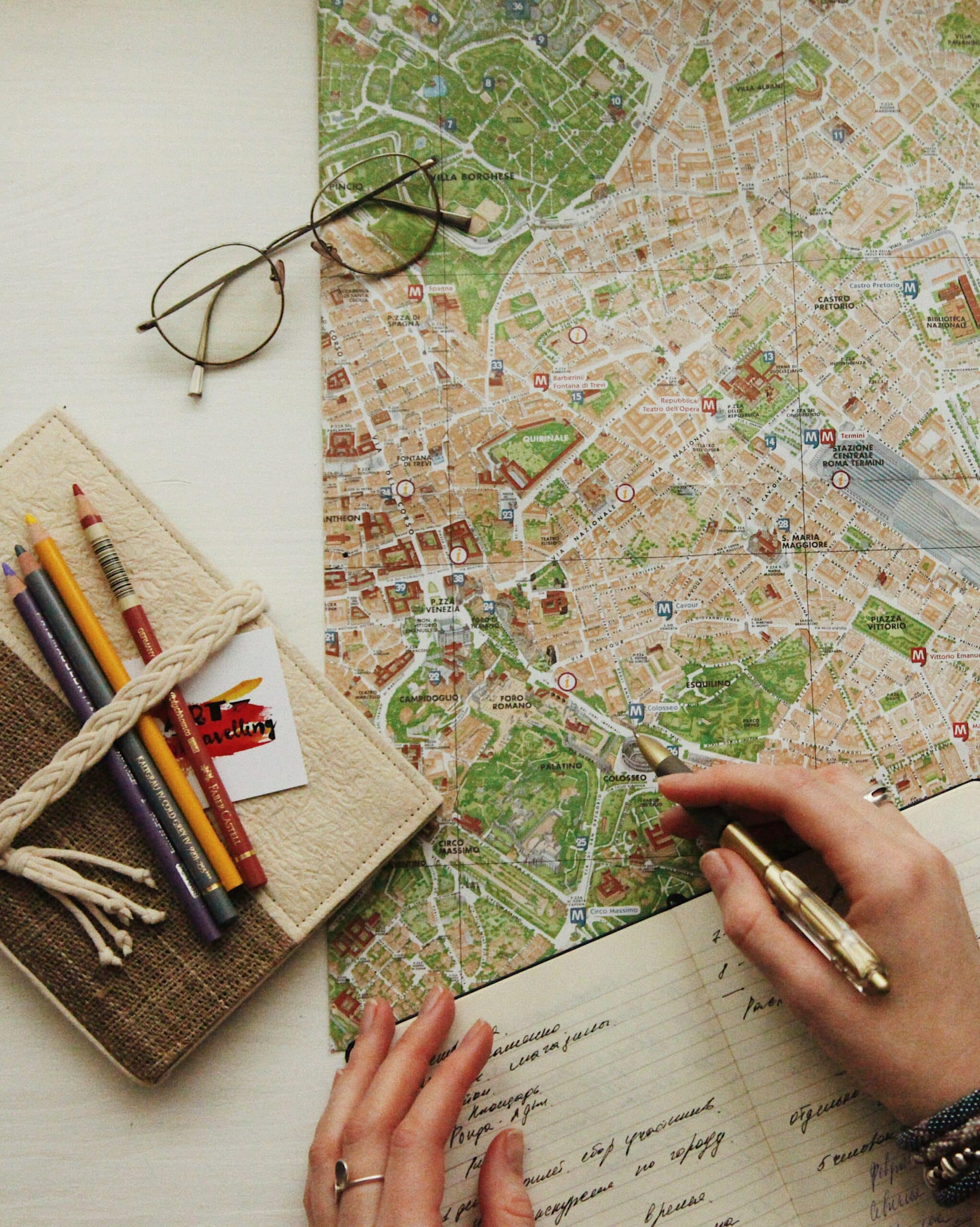 mulher planejando sua viagem com um seguro saúde anotando no caderno em cima de um mapa
