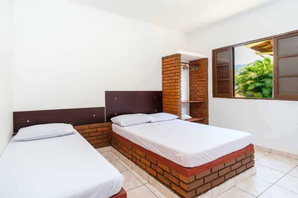 quarto com duas camas dos Chalés Mar Virado em Maranduba