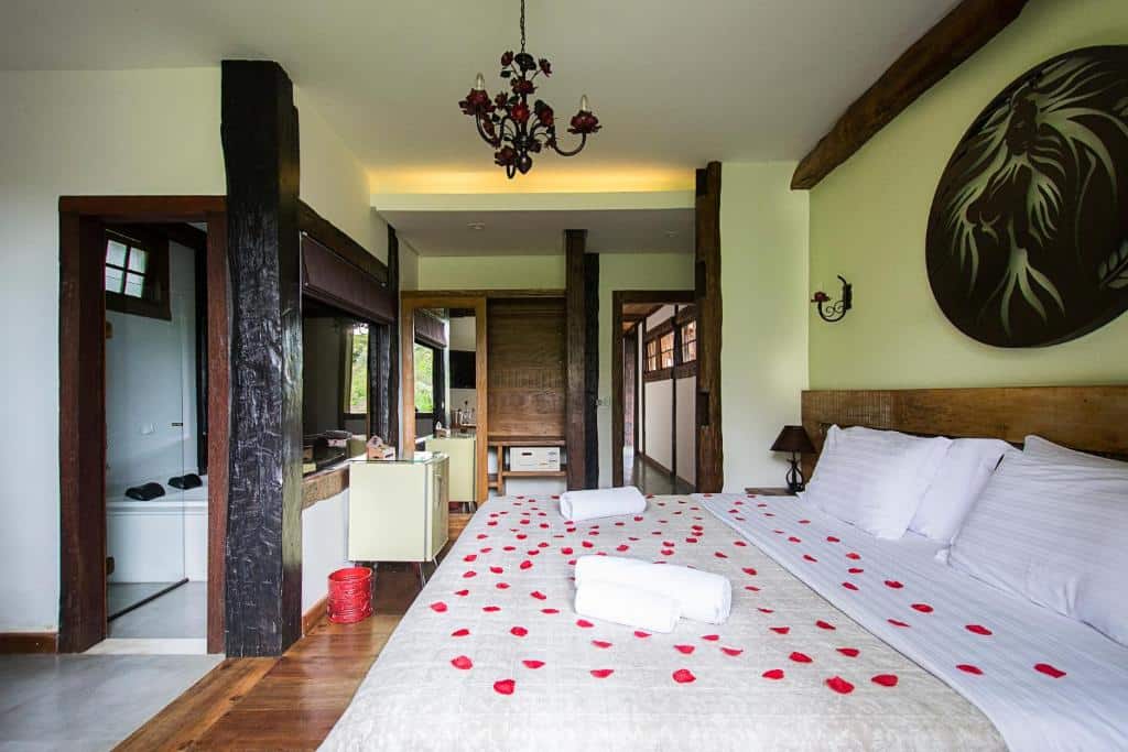 quarto da Pousada Chão de Minas Ouro Preto com uma cama de casal, banheira de hidromassagem e frigobar