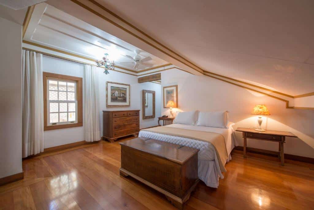 quarto espaçoso da Pousada do Douro com uma cama de casal duas cômdas e alguns quadros