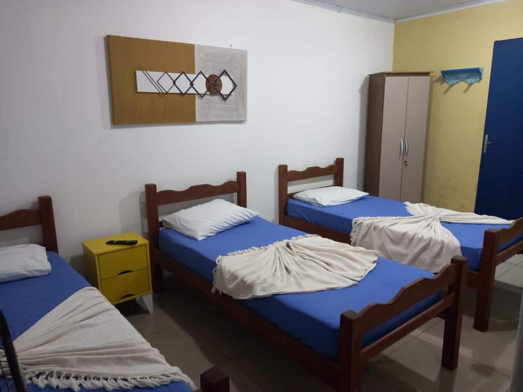 quarto da Pousada Vila Real - Pilar com três camas de solteiro e uma armário no canto