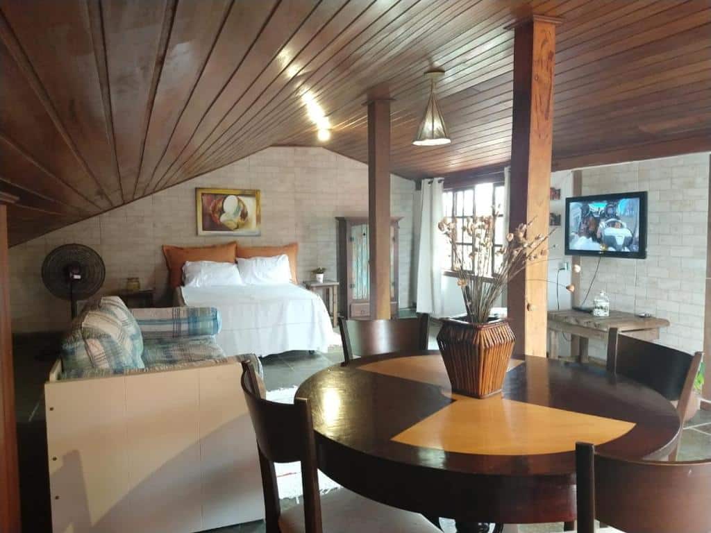 Imagem total do quarto, com cama, sala e área para alimentação da Suíte Fernanda