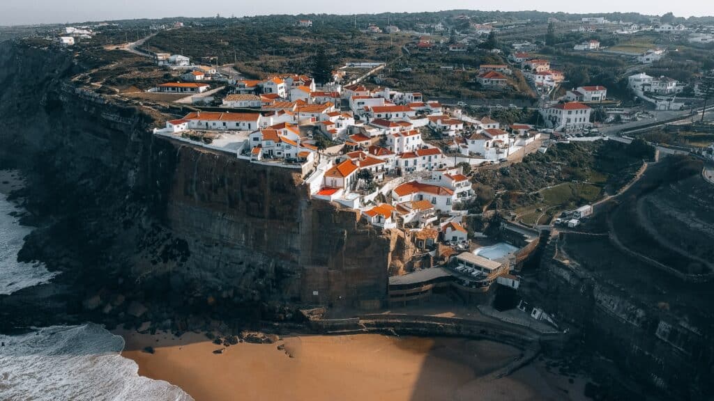 Casinhas brancas sobre encosta ao lado do mar, em Azenha do Mar, Portugal