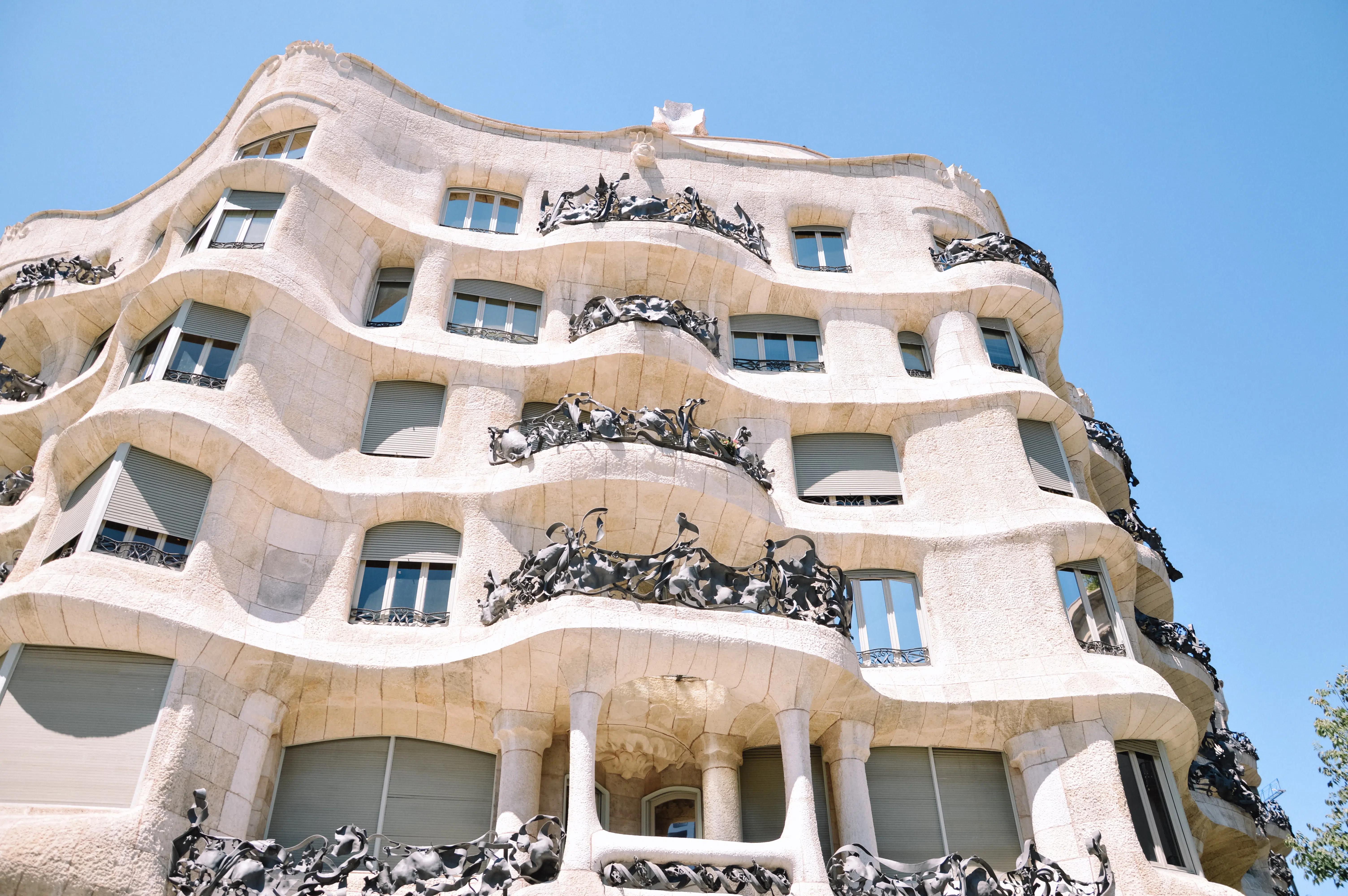 vista da fachada da Casa Milá, uma construção branca com escadas e janelas, que pode ser visitada com um seguro viagem Barcelona