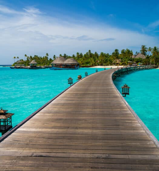 passarela de madeira em um resort que pode ser visitado com um seguro viagem maldivas